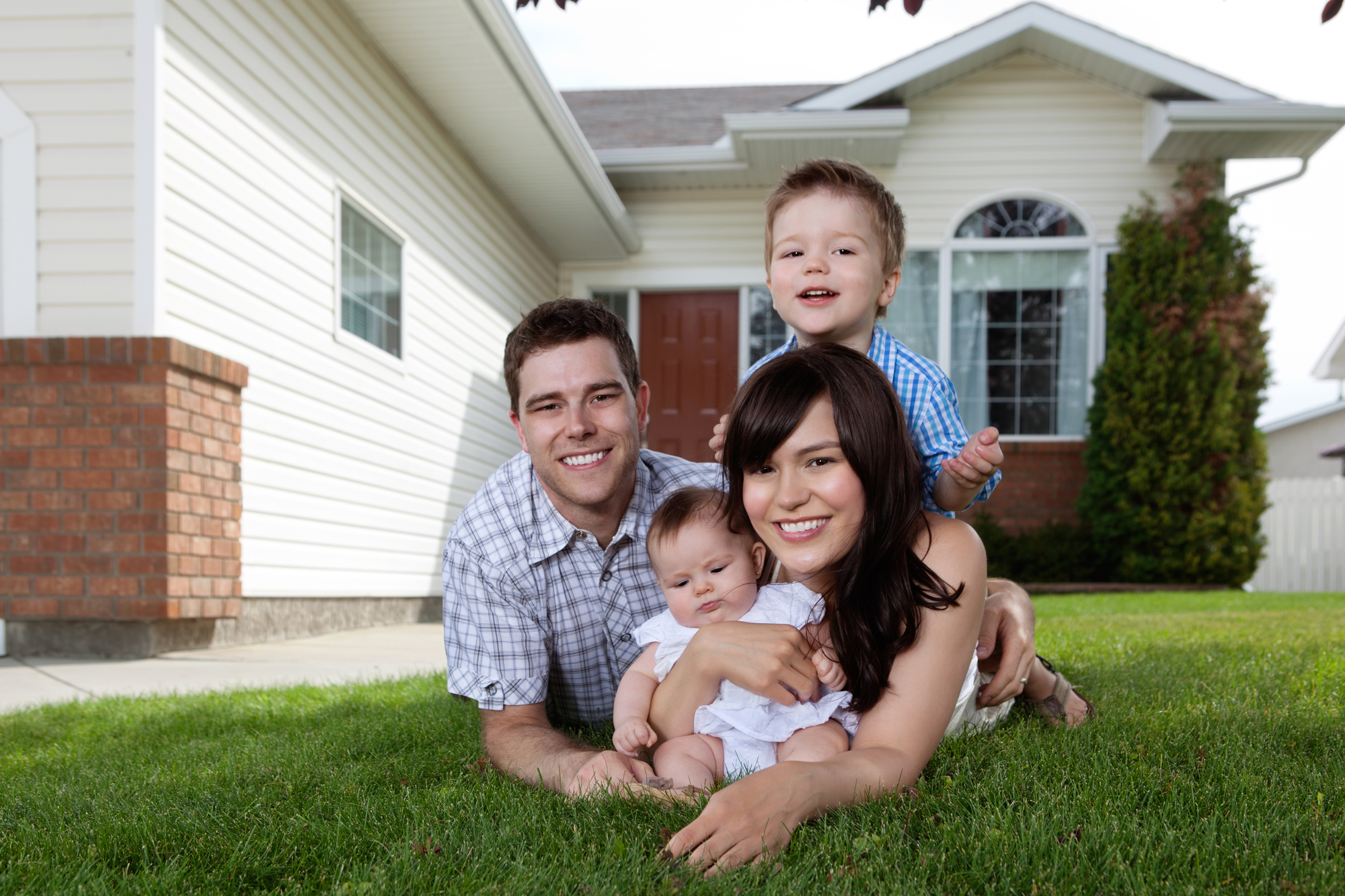 Family Laying in Grass in Front of Home with Homeowners Insurance in Santa Maria, CA